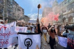 Protesters march holding slogans during a protest at Pazundaung township in Yangon, Myanmar, Wednesday July 14, 2021.