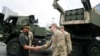 FILE - Philippine military chief Gen. Romeo Brawner Jr. left, greets US soldiers beside a HIMARS rocket launcher on display during the Asian Defense and Security Exhibition on Sept. 25, 2024, in Manila, Philippines. 