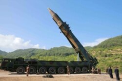 This file picture taken and released on July 4, 2017 by North Korea's official Korean Central News Agency shows North Korean leader Kim Jong Un (2nd R) inspecting the test-fire of the intercontinental ballistic missile Hwasong-14.