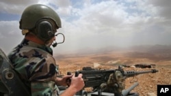 FILE - A Lebanese army soldier sits on a tank near the Syrian border, in northeast Lebanon. 