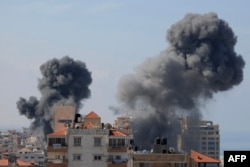 FILE - Smoke billows from residential buildings following Israeli airstrikes in Gaza City on October 7, 2023.