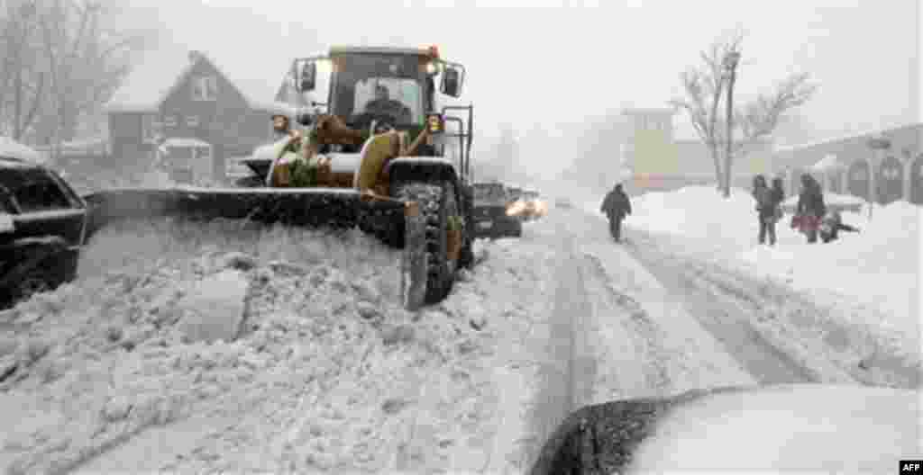 A plow driver clears snow from a road during a winter storm in South Buffalo, N.Y., Thursday, Dec. 2, 2010. (AP Photo/David Duprey)