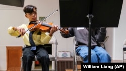 Giovanni Vazquez plays the violin during a string orchestra rehearsal at New Hope Presbyterian Church on Wednesday, Oct. 16, 2024, in Anaheim, California. (AP Photo/William Liang)