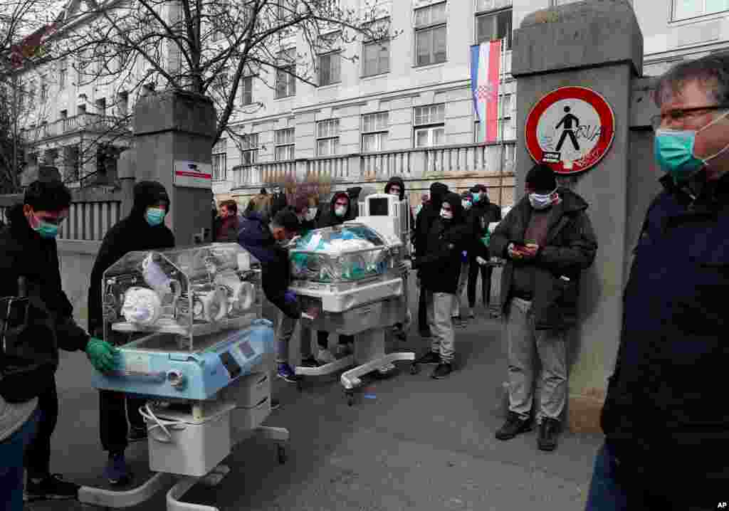 People carry incubators for newborn babies as the hospital is evacuated after an earthquake in Zagreb, Croatia.