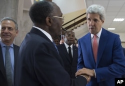 FILE - The Prime Minister of the DRC, Augustin Matata Ponyo, center, bids farewell to U.S Secretary of State John Kerry at the Palais de la Nation in Kinshasa, on May 4, 2014.