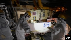 Employees of Tokyo Electric Power Company Holdings take AP journalists to the area under the Unit 5 reactor pressure vessel, which survived the 2011 tsunami, at the Fukushima Daiichi nuclear power plant in Futaba town, Japan, Feb. 20, 2025.