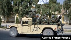 Taliban forces from the Al-Badr military corps sit on armed vehicles during a parade in Kandahar on Nov. 8, 2021.