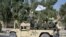Pasukan Taliban dari Korps Militer Al-Badr duduk di atas kendaraan bersenjata dalam sebuah parade di Kandahar, Afghanistan, pada 8 November 2021. (Foto: AFP/Javeed Tanveer)