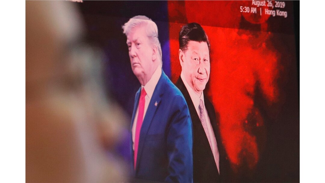 FILE - A computer screen shows images of Chinese President Xi Jinping, right, and U.S. President Donald Trump as a currency trader works at the KEB Hana Bank headquarters in Seoul, South Korea, Aug. 26, 2019.
