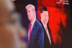 FILE - A computer screen shows images of Chinese President Xi Jinping, right, and U.S. President Donald Trump as a currency trader works at the KEB Hana Bank headquarters in Seoul, South Korea, Aug. 26, 2019.