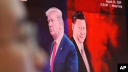 FILE - A computer screen shows images of Chinese President Xi Jinping, right, and U.S. President Donald Trump as a currency trader works at the KEB Hana Bank headquarters in Seoul, South Korea, Aug. 26, 2019.
