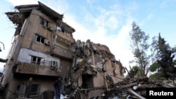 Un hombre se encuentra sobre los escombros de un edificio dañado, después de los ataques israelíes en los suburbios del sur de Beirut, en medio de las hostilidades en curso entre Hezbolá y las fuerzas israelíes, en el Líbano, el 26 de noviembre de 2024.