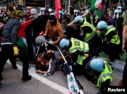 Para pengunjuk rasa bentrok dengan polisi selama protes untuk mendukung warga Palestina di dekat konsulat Israel, saat Konvensi Nasional Demokrat (DNC) di Chicago, Illinois, AS (20/8).