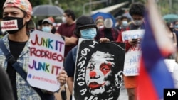 A protester holds a caricature of Philippine President Rodrigo Duterte during an anti-terror bill rally at the University of the Philippines in Manila, Philippines as they observe Philippine Independence Day on Friday, June 12, 2020. Hundreds of…