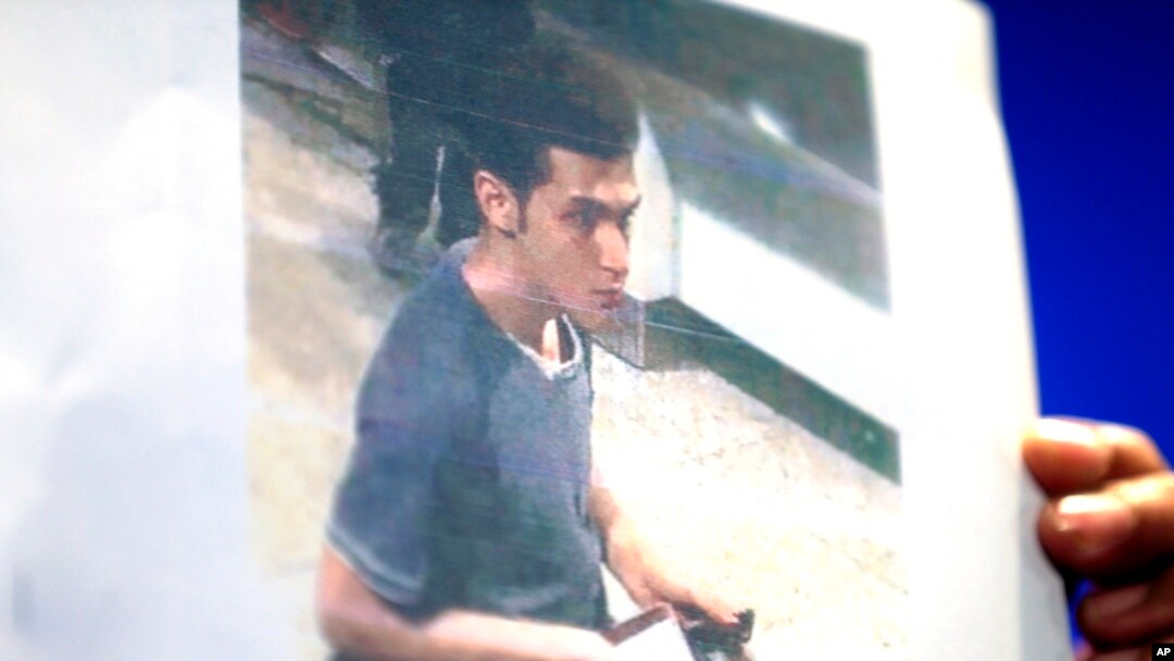 Seorang polisi perempuan Malaysia memegang foto warga Iran berusia 19 tahun yang diidentifikasi sebagai Pouria Nour Muhammad Mehrdad, sedang memasuki pesawat Malaysia Airlines dengan nomor penerbangan MH370 dengan paspor curian (11/3).
