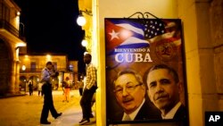 ຮູບປະທານາທິບໍດີຄິວບາ ທ່ານ Raul Castro (ຊ້າຍ) ແລະ ປະທານາທິບໍດີສະຫະລັດ ທ່ານ Barack Obama ເປັນພາສາສະເປນ ທີ່ມີຂໍ້ຄວາມວ່າ ຍິນດີຕ້ອນຮັບສູ່ຄິວບາ.
