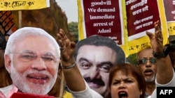 Para pekerja Partai Kongres mengacungkan poster dan meneriakkan slogan memprotes Perdana Menteri India Narendra Modi dan miliarder Gautam Adani, meminta penahanan Adani yang didakwa kasus korupsi di Amerika Serikat, Jumat, 22 November 2024. (Foto: Dibyangshu Sarkar/AFP)