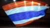 A supporter of the Thai monarchy waves a giant national flag during a rally in Bangkok, Thailand.