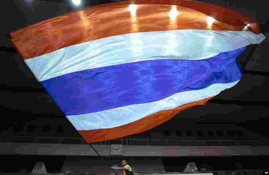 A supporter of the Thai monarchy waves a giant national flag during a rally in Bangkok, Thailand.