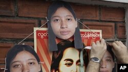 A Myanmar activist puts cutouts of imprisoned Hla Hla Win, a reporter of the Norway-based Democratic Voice of Burma, on a wall near Myanmar Embassy during a rally in Bangkok, Thailand, (File September 9, 2011).