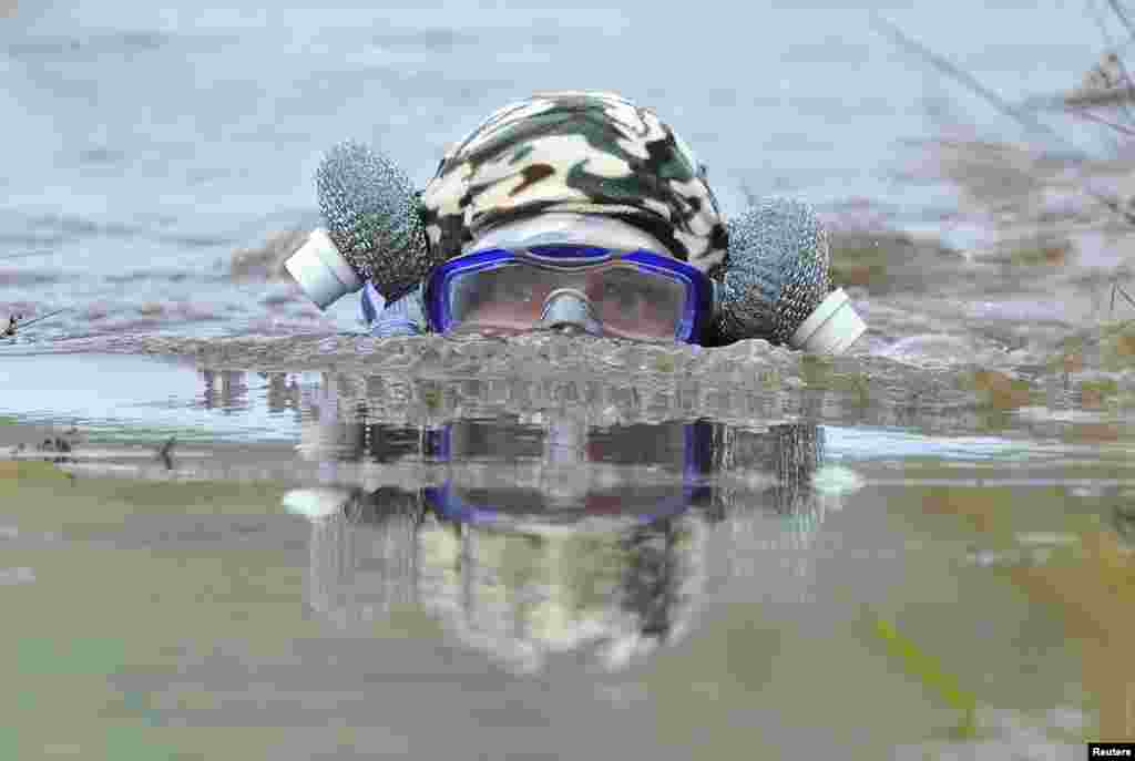 Simon Reynolds competes in the World Bog Snorkelling Championships at Waen Rhydd bog on the outskirts of Lanwrtyd Wells, Powys, Wales, Britain.