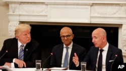 Dalam arsip foto 19 Juni 2017, Presiden Donald Trump, (kiri) dan Satya Nadella, Chief Executive Officer (CEO) Microsoft, berbincang dengan CEO Amazon Jeff Bezos.