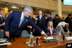 FILE - Italian Foreign Minister Antonio Tajani moves the Tunisia placeholder during an International conference on migration in Rome, Sunday, July 23, 2023.