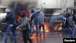 Manifestantes lanzan piedras y cocteles molotov contra la policía durante protestas en Kiev.