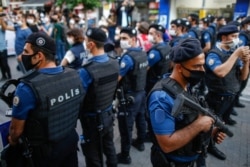 FILE - Turkish police officers in riot gear block supporters of pro-Kurdish Peoples' Democratic Party (HDP) as they try to gather for a rally in Istanbul, June 17, 2020.