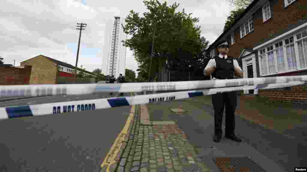 Police officers guard a cordon set up around a crime scene where one man was killed was killed in Woolwich, southeast London May 22, 2013.