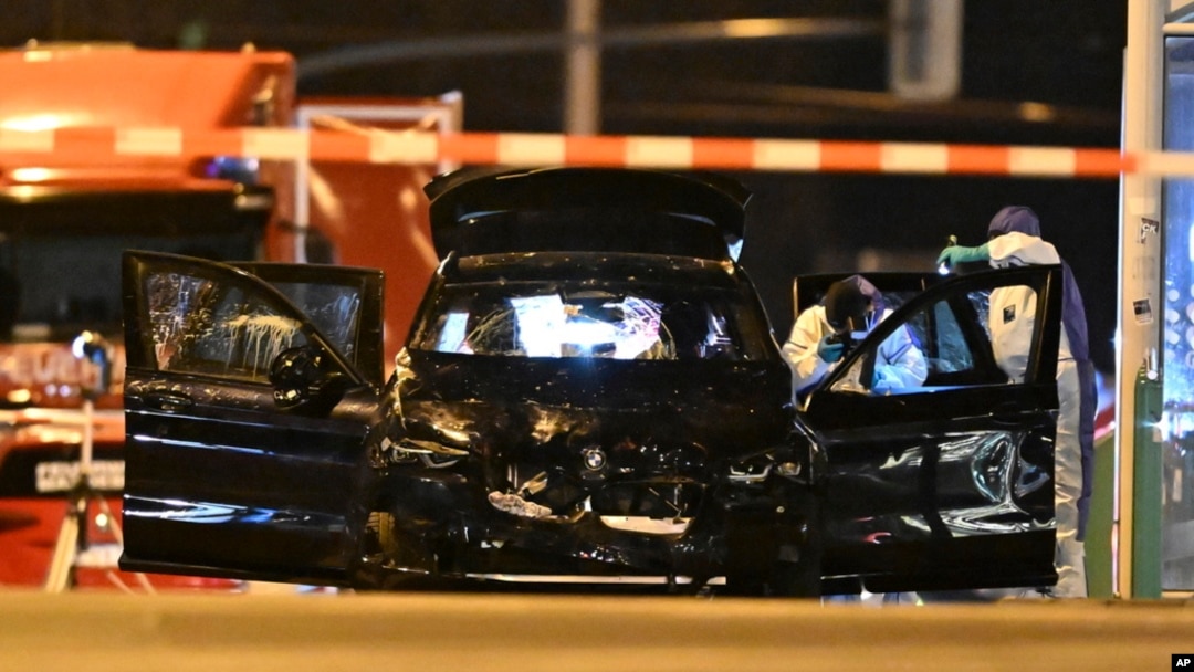 Forensic technicians work on a damaged car sitting with its doors open after a driver plowed into a busy Christmas market in Magdeburg, Germany, Dec. 21, 2024.