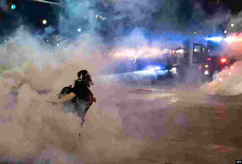 A protester hurls a tear gas canister back towards the Detroit police after tensions were sparked by arrests of protesters, through the streets of Detroit, Michigan for a second night May 30, 2020, to protest the killing of George Floyd.