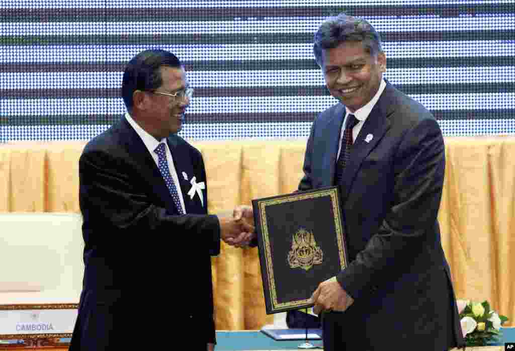 ທ່ານ ຮຸນ ເຊນ ນາຍົກລັດຖະມົນຕີກໍາປູເຈຍ ແລະເລຂາທິການໃຫຍ່ ຂອງສະມາຄົມອາຊ່ຽນ, ທ່ານສຸຣິນ ພິດສຸວັນ ຖືຄຳ​ປະກາດດ້ານສິດທິມະນຸດ ທີ່ຫາກໍ່ຖືກຮັບຮອງເອົາ ຢູ່ໃນກອງປະຊຸມສຸດຍອດຂອງອາຊ່ຽນ ທີ່ຈັດຂຶ້ນ ໃນນະຄອນພະນົມເປັນ ຂອງກໍາປູເຈຍ ໃນວັນທີ 18 ພະຈິກ 2012.