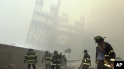 FILE - Firefighters work beneath the destroyed mullions, the vertical struts which once faced the soaring outer walls of the World Trade Center towers, after a terrorist attack on the twin towers in New York, Sept. 11, 2001. 