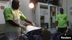 A doctor (L) performs circumcision on an unidentified politician in an effort to reduce the spread of HIV, in Harare, Zimbabwe.