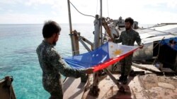 Marinir Filipina melipat bendera nasional Filipina di Second Thomas Shoal yang disengketakan, bagian dari Kepulauan Spratly di Laut Cina Selatan. (Foto: REUTERS/Erik De Castro)