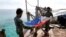 Marinir Filipina melipat bendera nasional Filipina di Second Thomas Shoal yang disengketakan, bagian dari Kepulauan Spratly di Laut Cina Selatan. (Foto: REUTERS/Erik De Castro)