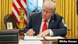 Trump signs executive order in oval office.