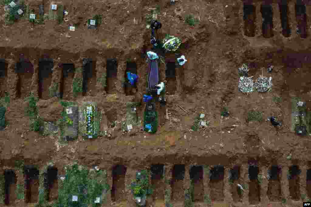 Gravediggers bury an alleged COVID-19 victim at the Vila Formosa Cemetery, in the outskirts of Sao Paulo, Brazil. 