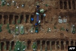 Gravediggers bury an alleged COVID-19 victim at the Vila Formosa Cemetery, in the outskirts of Sao Paulo, Brazil, May 22, 2020.