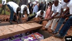 Des volontaires déposent dans caveau les restes des victimes du génocide de 1994, à Murambi, est du Rwanda, 07 avril 2005. epa / RICKY GARE