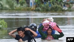 Residents evacuate as floodwaters submerged areas of Ye township in Mon State, Myanmar, Aug. 11, 2019.