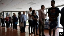 FILE - People stand in line to register for a job fair in Miami Lakes, Florida, July 19, 2016.