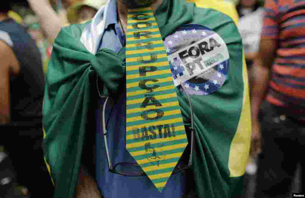 Com uma gravata e a bandeira nas costas, manifestante protesta a corrupção do governo