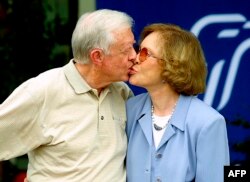 FILE — Former US president Jimmy Carter receives a kiss from his wife Rosalynn Carter after a press conference in Plains, Georgia, on October 11, 2002.