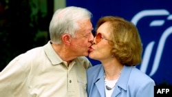 FILE — Former US president Jimmy Carter receives a kiss from his wife Rosalynn Carter after a press conference in Plains, Georgia, on October 11, 2002