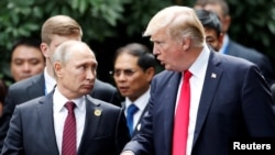 U.S. President Donald Trump and Russia's President Vladimir Putin talk during the photo session at the APEC Summit in Danang, Vietnam, Nov. 11, 2017.