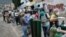 La gente espera con sus tanques de oxígeno vacíos afuera de una tienda de recarga, para llevárselos a sus familiares con COVID-19 en Caracas, Venezuela. Abril 9, 2021.