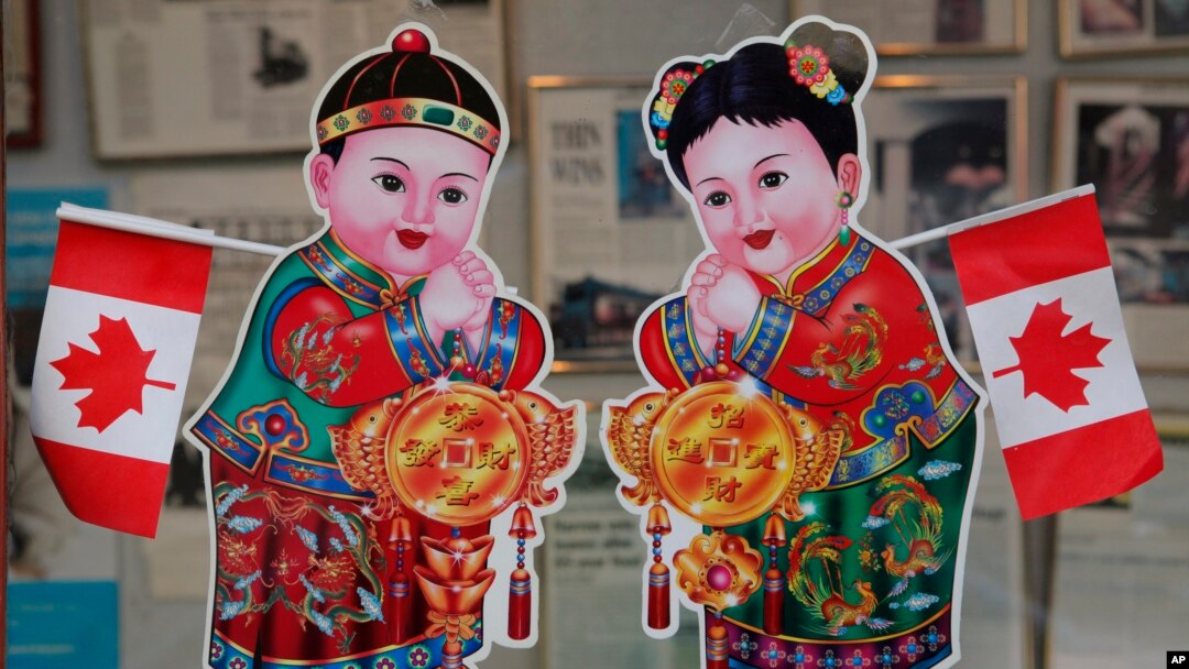 2010年2月18日，加拿大的不列顛哥倫比亞省的溫哥華，在中國城一座商業大樓的入口處，有加拿大國旗和華人慶祝農曆新年的招財進寶童男童女畫像。