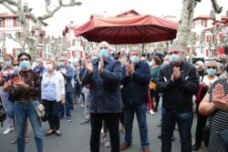Residents applaud after observing a minute of silence for slain history teacher Samuel Paty, Oct.21, 2020, in Saint-Jean-de-Luz, southwestern France.